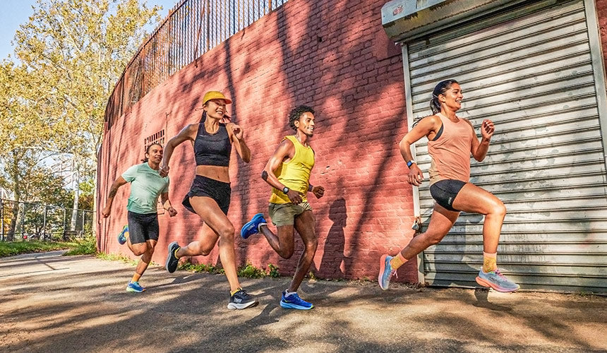 group of women and men running in hoka running shoes