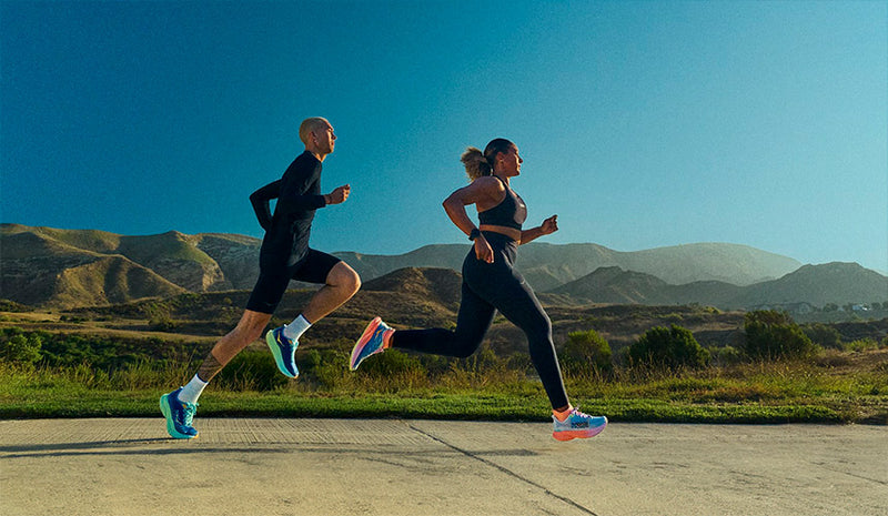 woman and man running outside in hoka running shoes