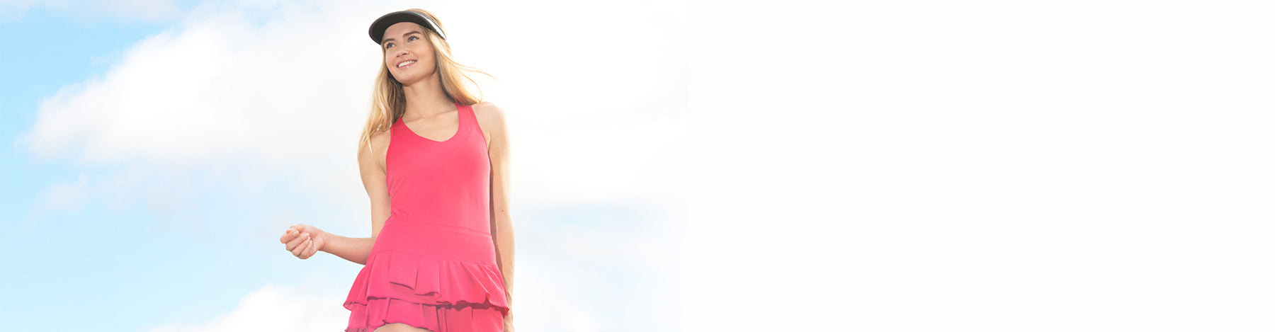 Woman wearing a pink Lucky in Love V-Neck Tank and Wavy Pleat Tier Skirt against a cloudy blue sky background.