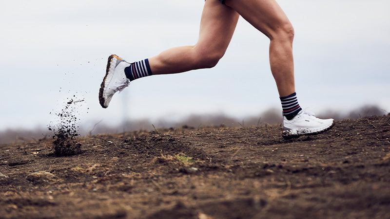 Person running on a dirt path in norda 001 trail running shoes