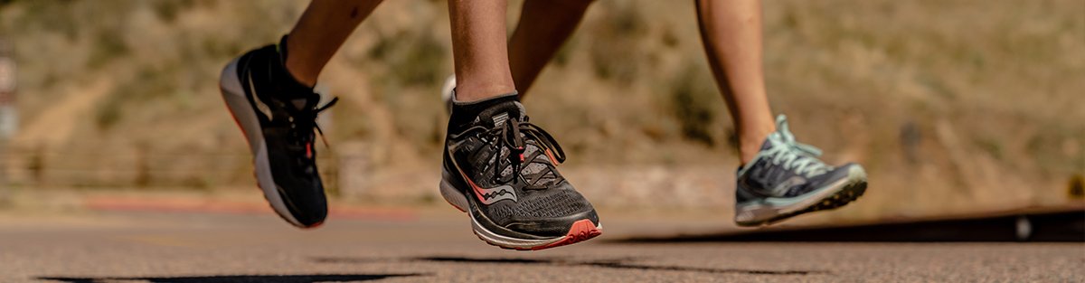 Man and woman running in Saucony Guide ISO 2