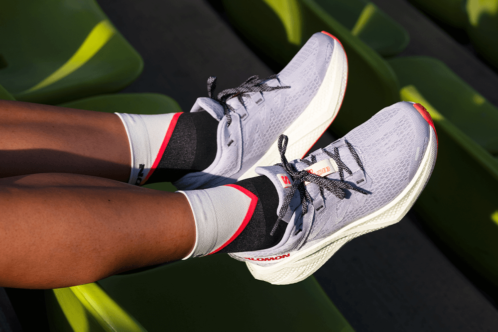 A pair of Salomon Aero Glide 3 running shoes on feet.