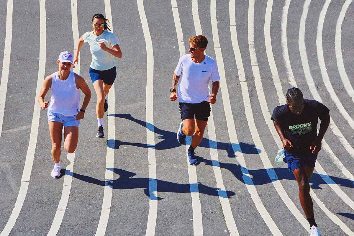 Five runners on a curved track in Brooks running clothing and shoes