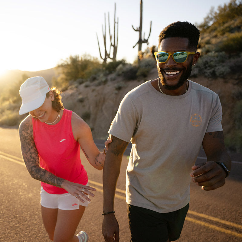 Runners walking on a dessert road in Brooks running clothing.