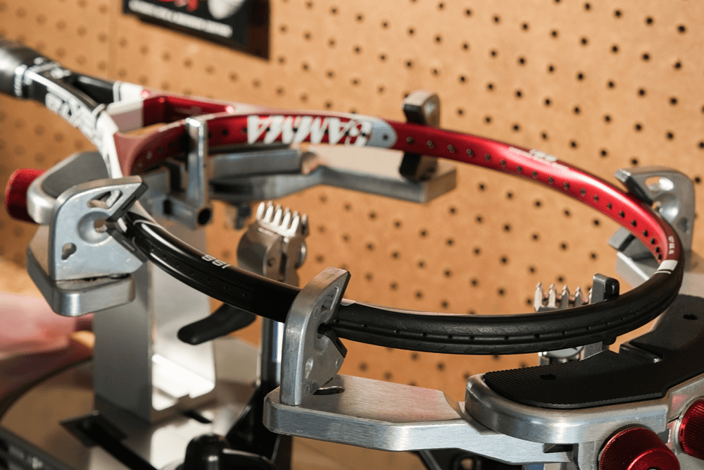 A tennis racquet being strung with a Gamma Momentum Stringing Machine.