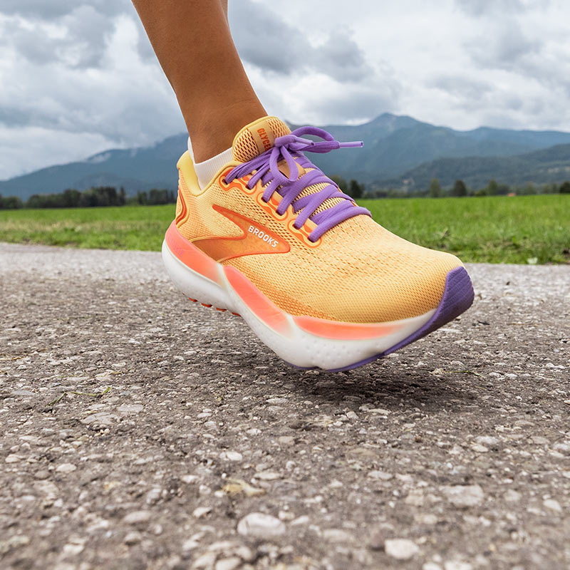 Lifestyle image: Closeup of a person running a country road in women's Brooks Glycerin 21 running shoes.