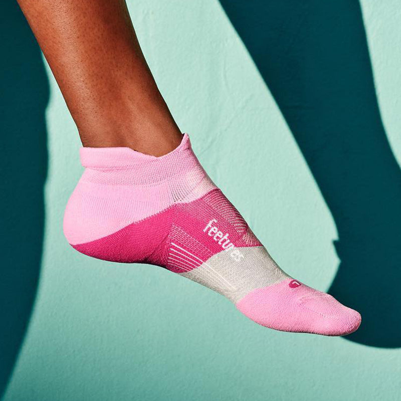 Lifestyle image. Closeup of a person wearing pink Feetures running socks.