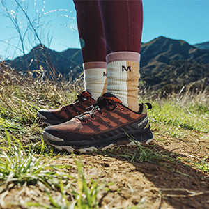 Closeup of a person standing on a mountain trail in Merrell hiking shoes