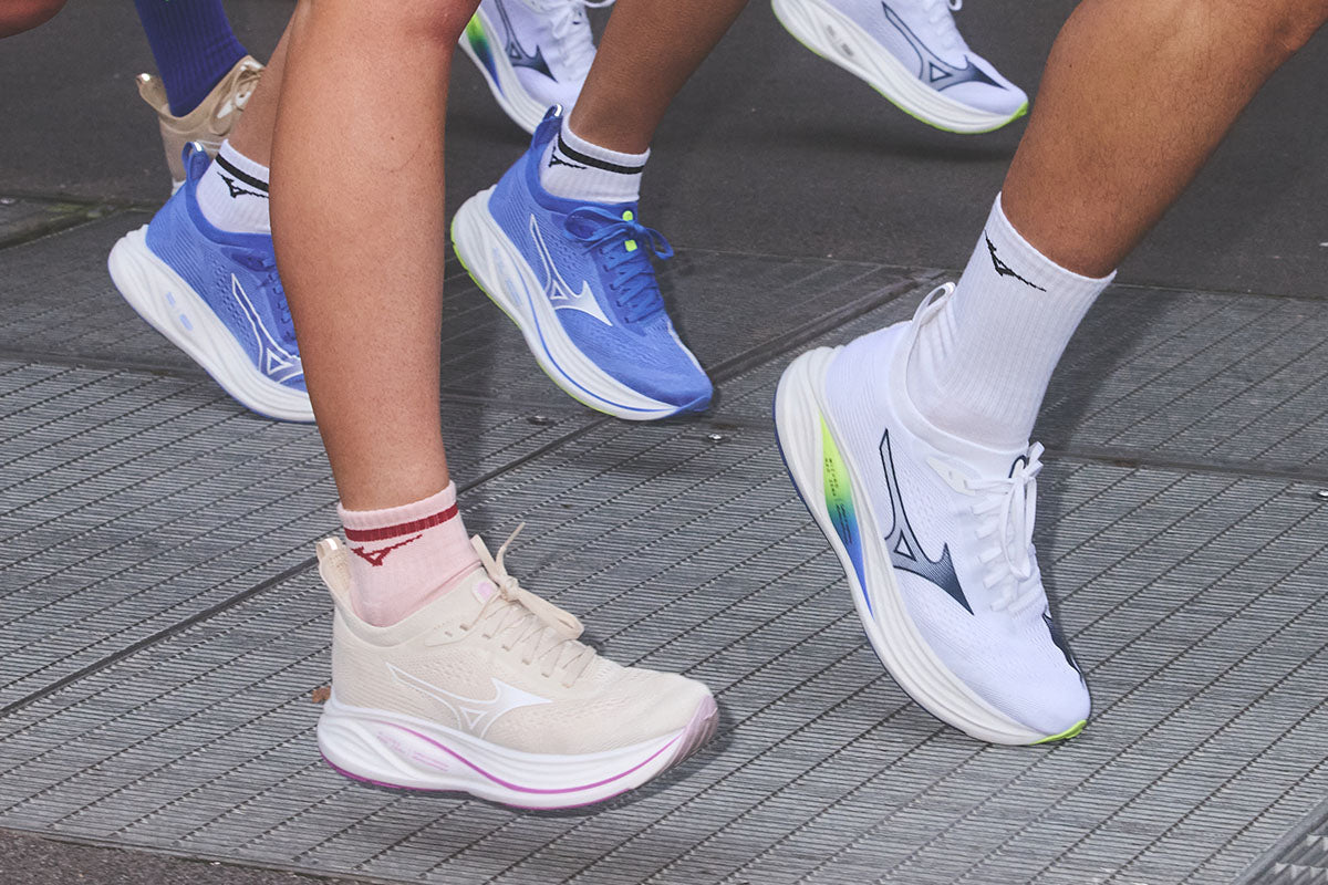 Close-up of people running in Mizuno Neo Zen 2 running shoes on a city sidewalk.