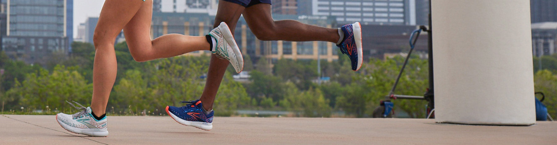 A woman and a man running through a city park in Brooks Glycerin 20 running shoes.