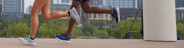 A woman and a man running through a city park in Brooks Glycerin 20 running shoes.