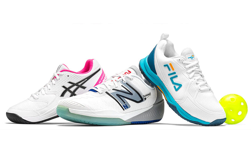 Wilson Rush Pro 3.0 Women's Chambry Blue/White/Outer Space and Men's Black/White/Infrared pickleball shoes sitting on a light blue, outdoor court.