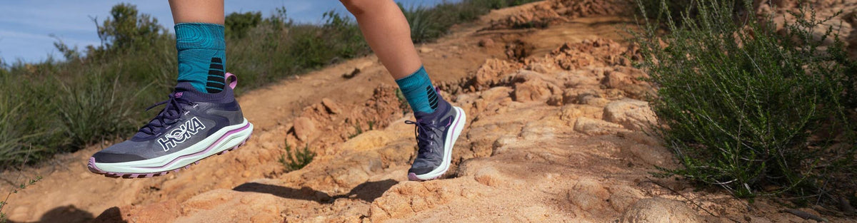A person running a desert trail in HOKA Zinal 2 trail running shoes.