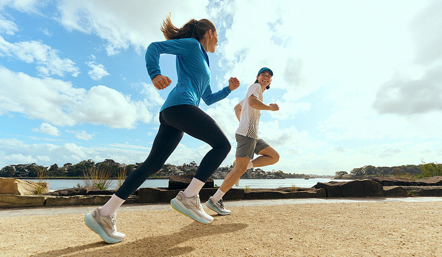 man and woman wearing brooks glycerin 21 running shoes running along water's edge