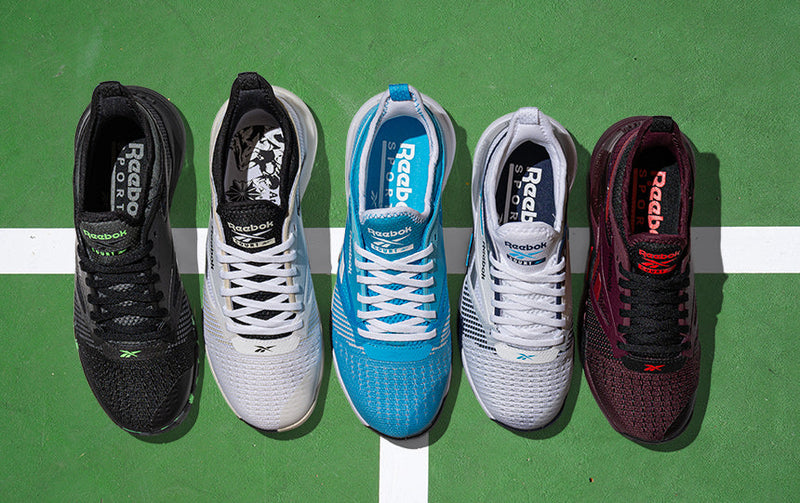 Reebok Nano Court tennis shoes on a blue pickleball court