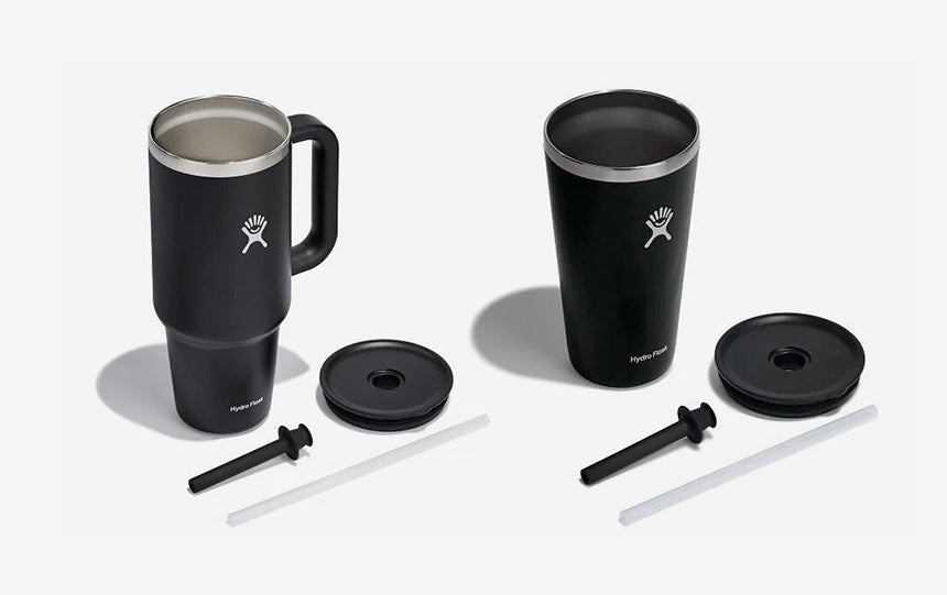 Black Hydro Flask travel tumbler and tumbler mug with accessories on a white background