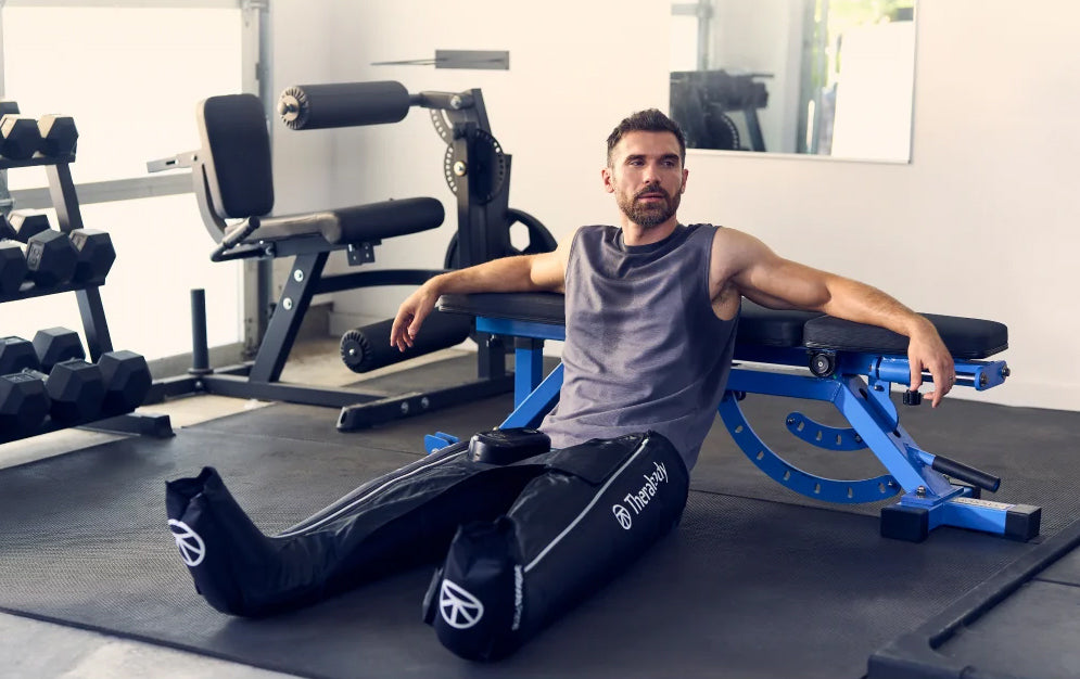 A person using Therabody RecoveryAir JetBoots in a gym.