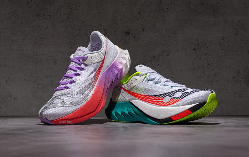 Two Saucony Endorphin Pro 4 running shoes on a gray background