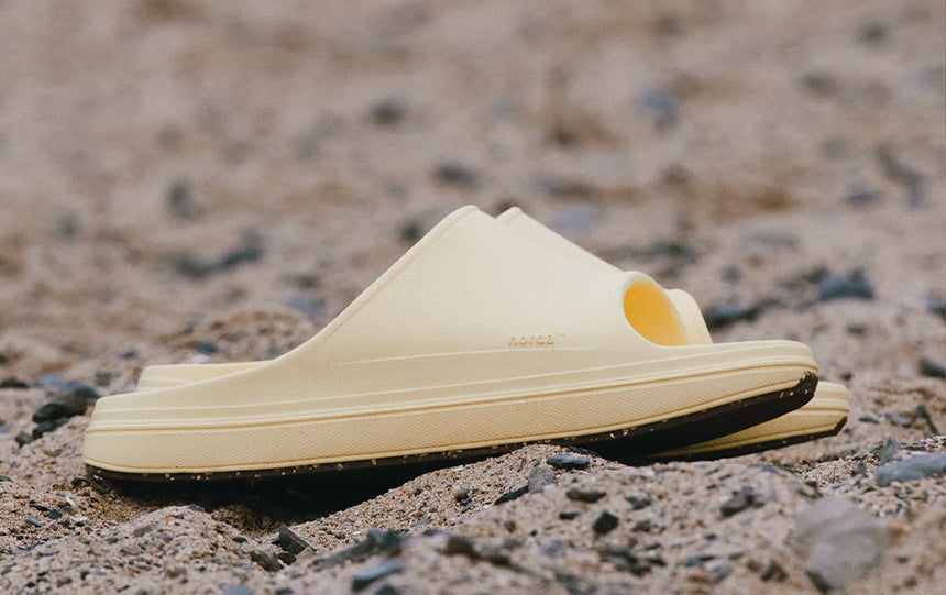 norda recovery sandals sitting on sandy ground