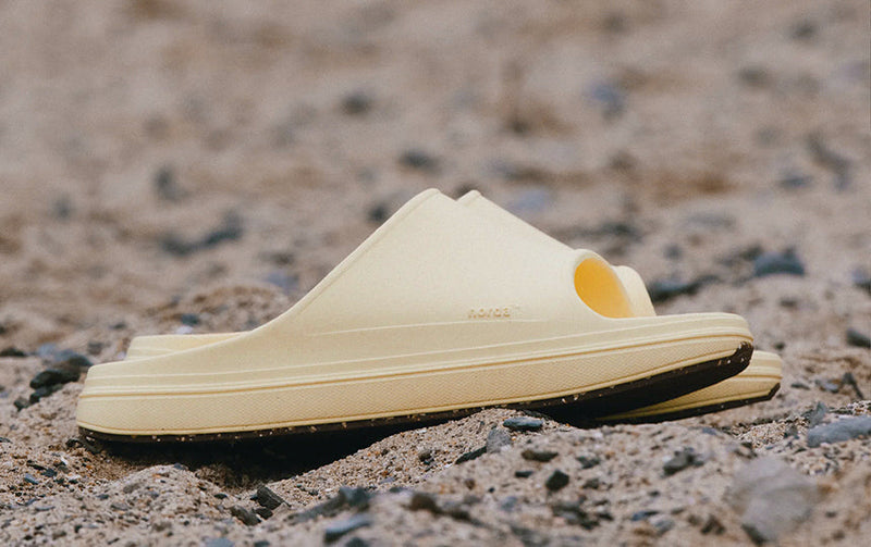norda recovery sandals sitting on sandy ground