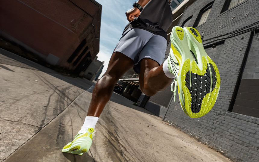 a man running a sidewalk in Puma Deviate NITRO 4 running shoes