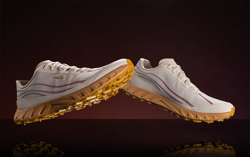 norda trail running shoes floating over a reflective surface against a maroon gradient background