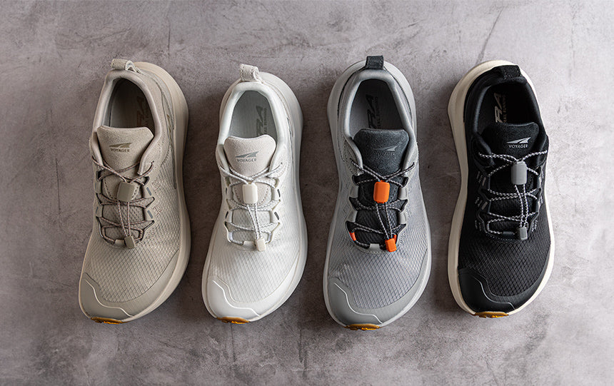 Four Altra Voyager lifestyle shoes in different colors lined up on a concrete floor