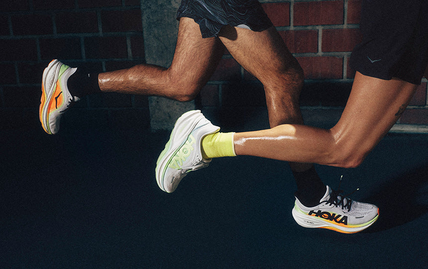 People running down the road in HOKA Clifton Pro running shoes.