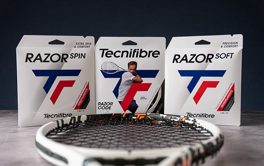Three sets of Tecnifibre tennis string posed upright with a tennis racquet head in the foreground