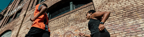 Man and woman running in adidas running gear in city