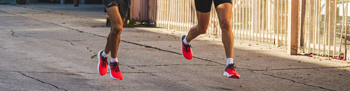 Man and woman running on road in Altra Vanish Carbon running shoes