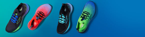 Four bright-colored Brooks Chromatic Pack running shoes on a teal and blue gradiant background