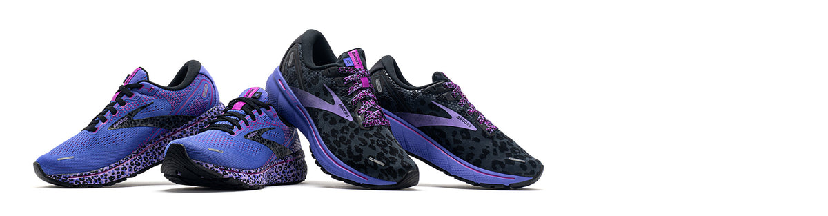Brooks Ghost 14 Electric Cheetah Run Wild women's running shoes on a white background. Cactus features a purple upper with pink accents and a black and pink cheetah pattern. Ebony features a black cheetah print with purple and pink accents.