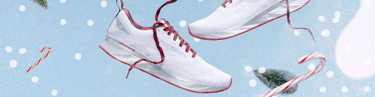 Brooks Holiday-themed running shoes on a blue winter background with snow, pine trees and candy canes.