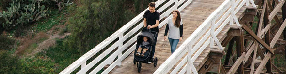 Parents pushing baby in Bumbleride Indie All-Terrain Stroller