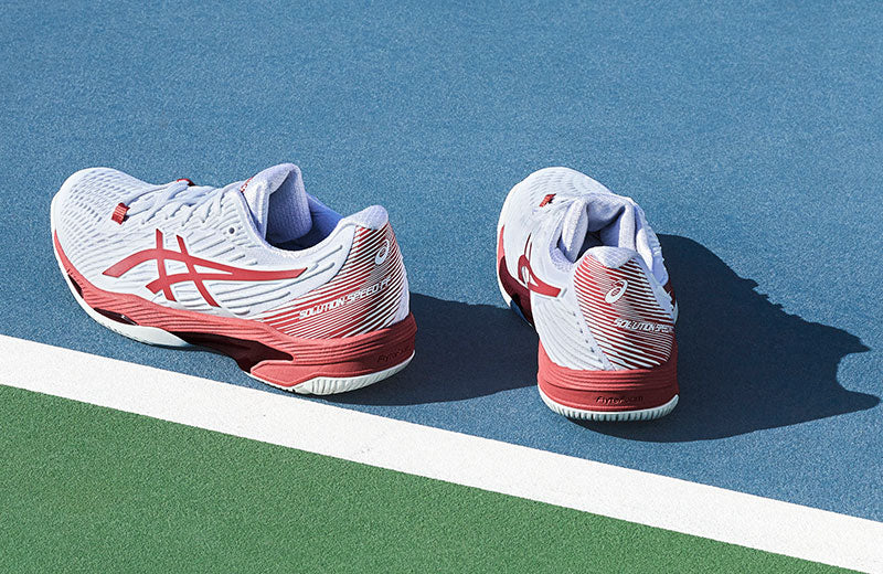 ASICS Solution Speed FF 2 tennis shoes on a blue and green court.