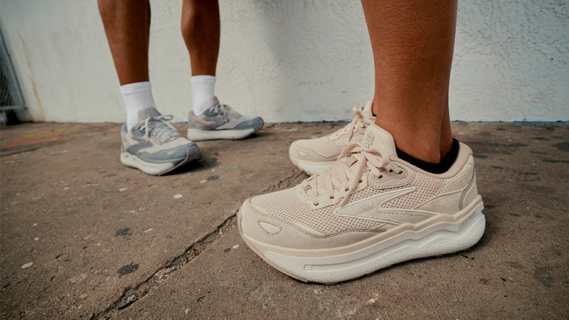 People standing on a sidewalk in Brooks Ghost Max SE walking shoes against a white wall