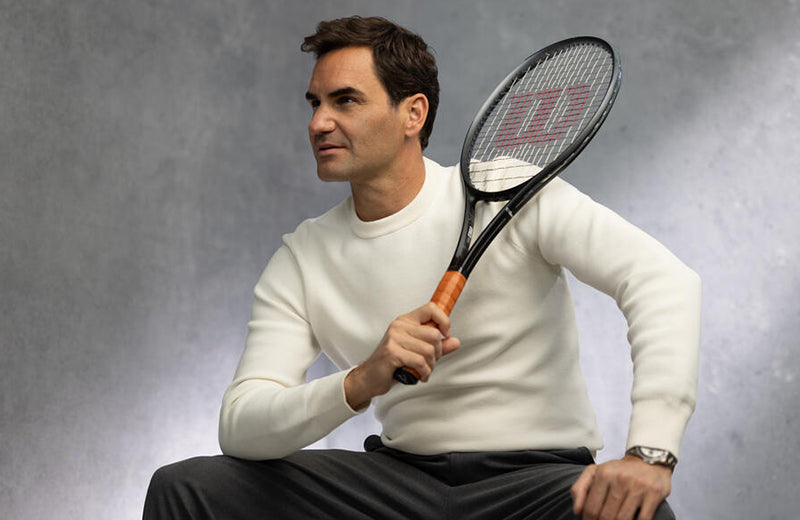 Roger Federer posing with a Wilson RF tennis racquet.