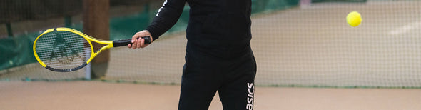 Man swinging a Dunlop SX series tennis racquet at a tennis ball.