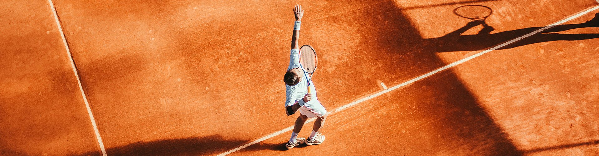 Man serving on tennis court