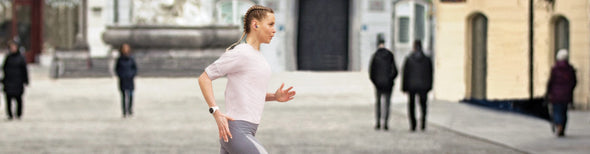 Woman running with Garmin GPS watch