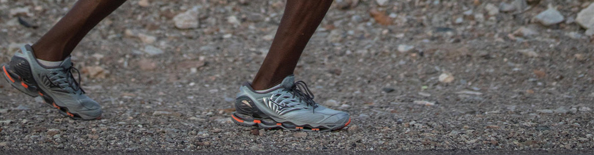 Man and woman in neighborhood running in Mizuno running shoes and clothing