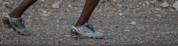 Man and woman in neighborhood running in Mizuno running shoes and clothing