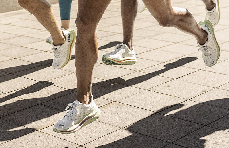 People running together in HOKA Kawana running shoes.