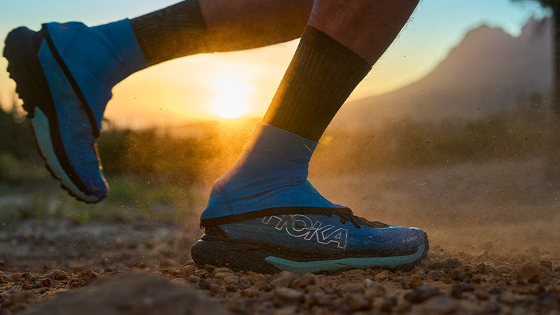Person running a dirt path in HOKA Mafate 5 trail running shoes