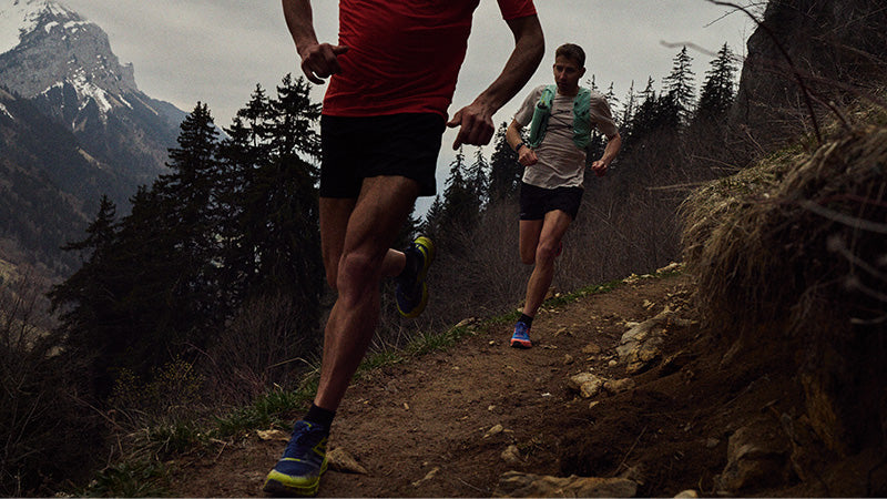 Two runners on a mountain trail wearing INOV8 Trailfly Max trail running shoes