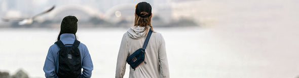 Women standing in front of sea wearing Nathan RunAway hydration packs