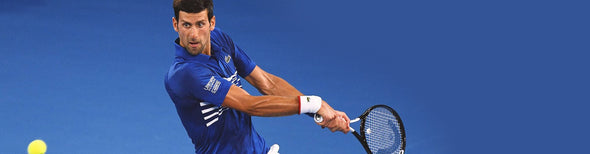 Man serving tennis ball on court