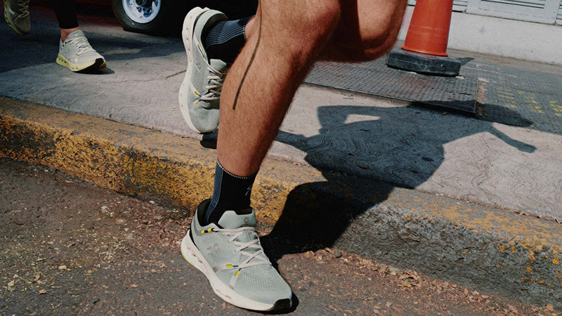 People running on a city sidewalk in On Cloudsurfer 2 running shoes