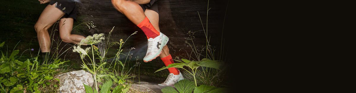 two people running through the woods at night in On Cloudventure Peak 3 trail running shoes